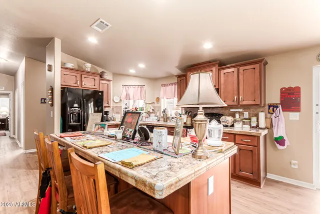 a kitchen with stainless steel appliances granite countertop a table chairs and a refrigerator