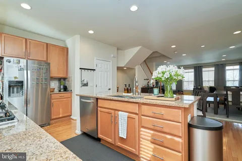 a kitchen with stainless steel appliances kitchen island granite countertop a refrigerator and cabinets