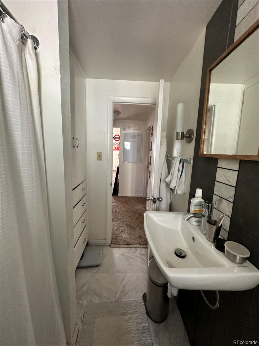 1265 Yates Street Denver, CO 80204 - Photo 14 of 17 a bathroom with a sink a toilet a mirror and shower