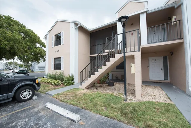 a view of a house with a small yard and plants