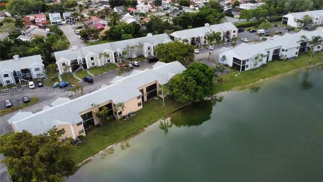 an aerial view of residential houses with outdoor space and lake view