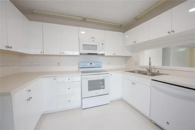a kitchen with cabinets stainless steel appliances and a sink