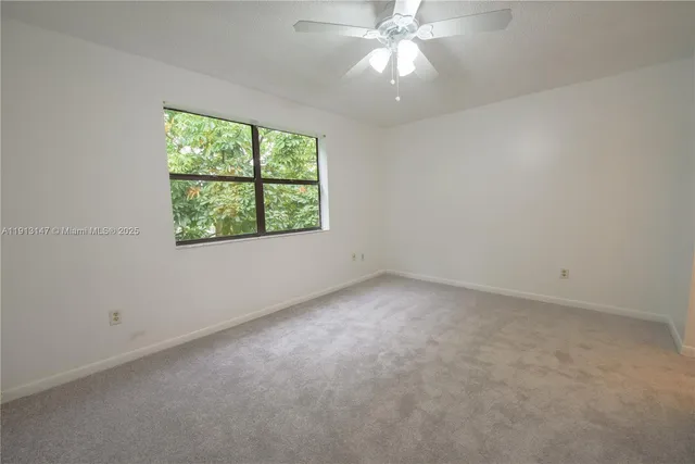 an empty room with a window and a fan