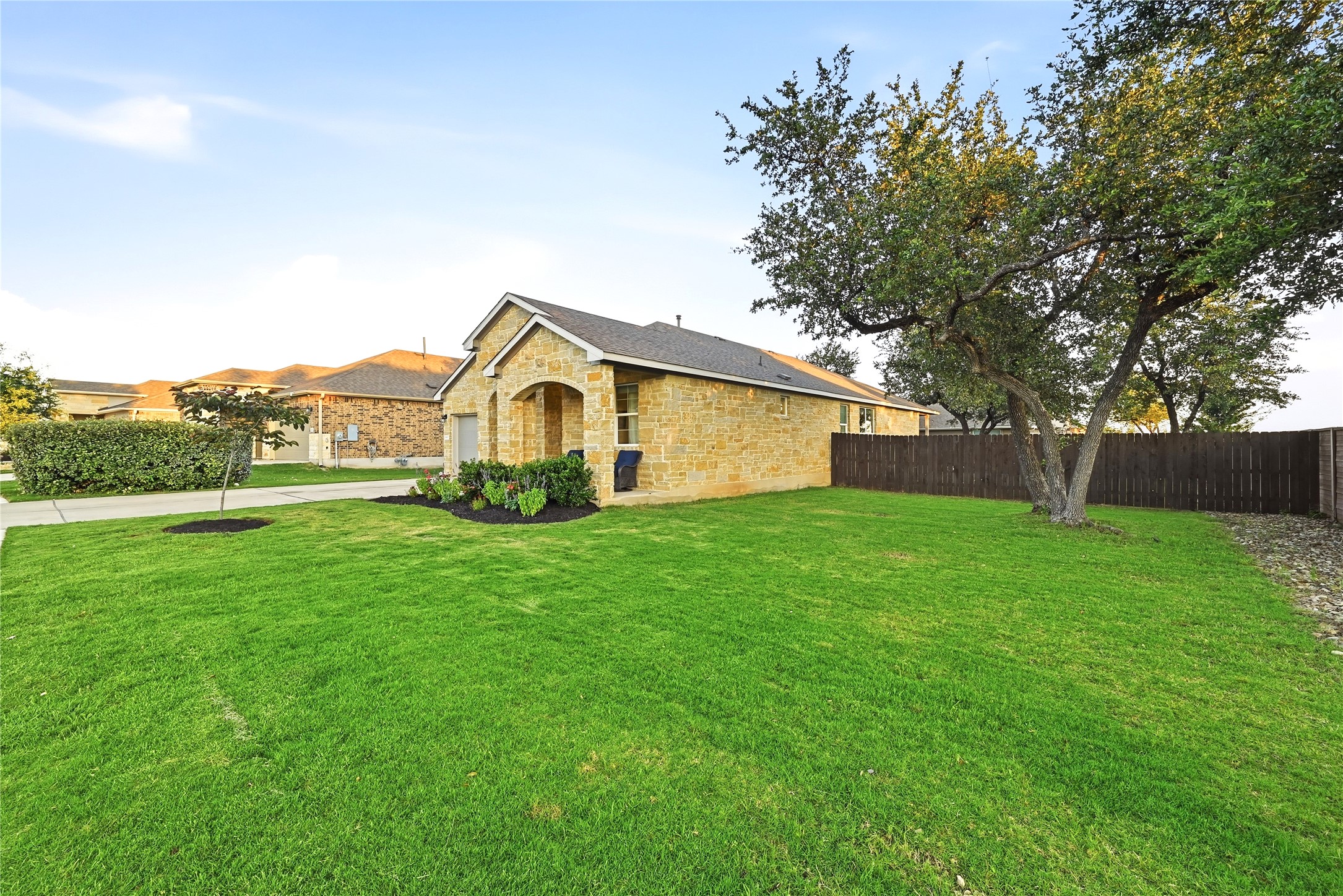 4420 Ingram Road Georgetown, TX 78628 - Photo 7 of 40 Well-maintained lawn frames this inviting stone-clad residence with a welcoming covered entry.