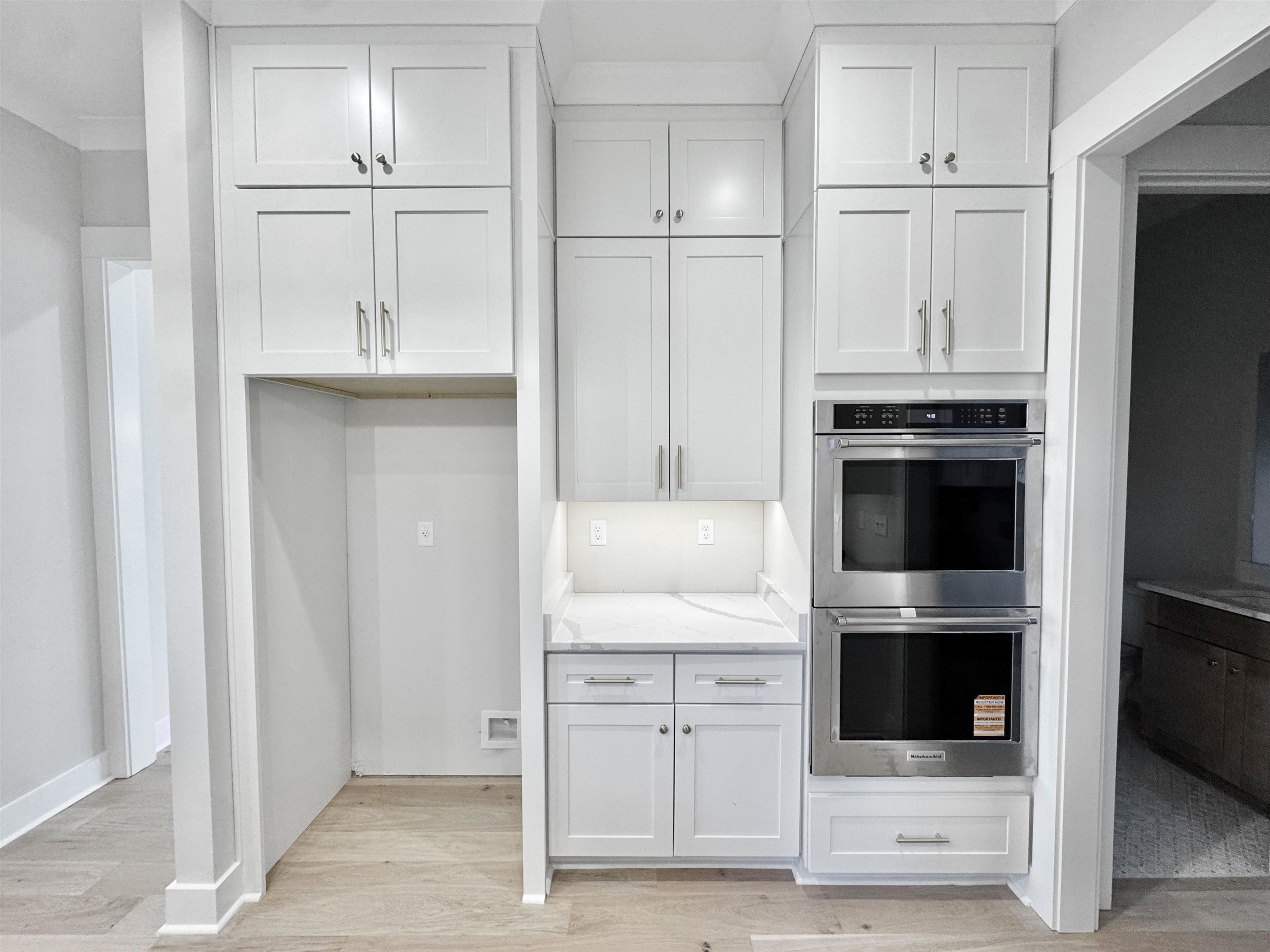 354 Avon Road Memphis, TN 38117 - Photo 11 of 40 Kitchen with double oven, light wood-style flooring, light stone countertops, and white cabinets