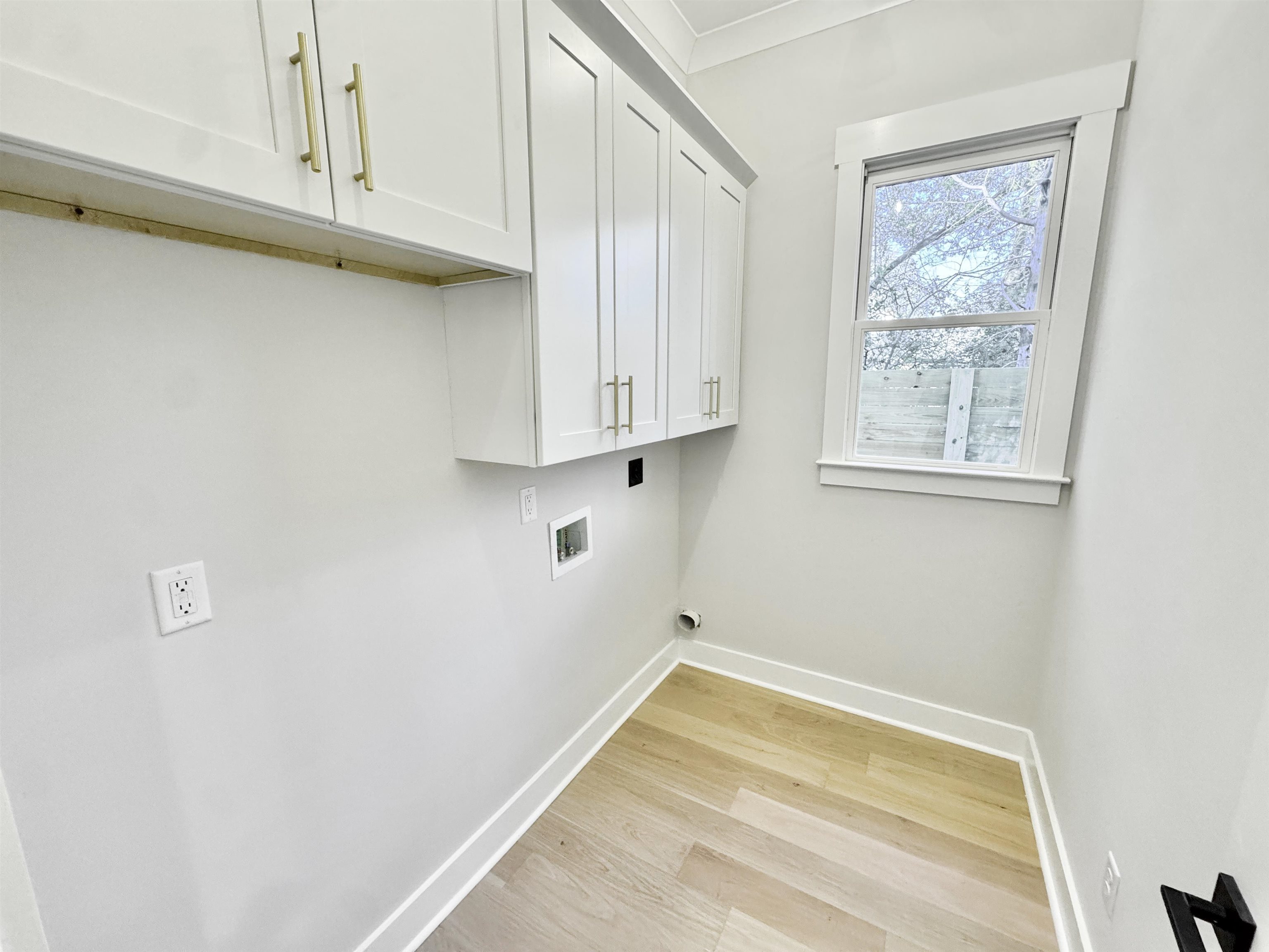 354 Avon Road Memphis, TN 38117 - Photo 27 of 40 Washroom featuring cabinet space, light wood finished floors, crown molding, washer hookup, and electric dryer hookup