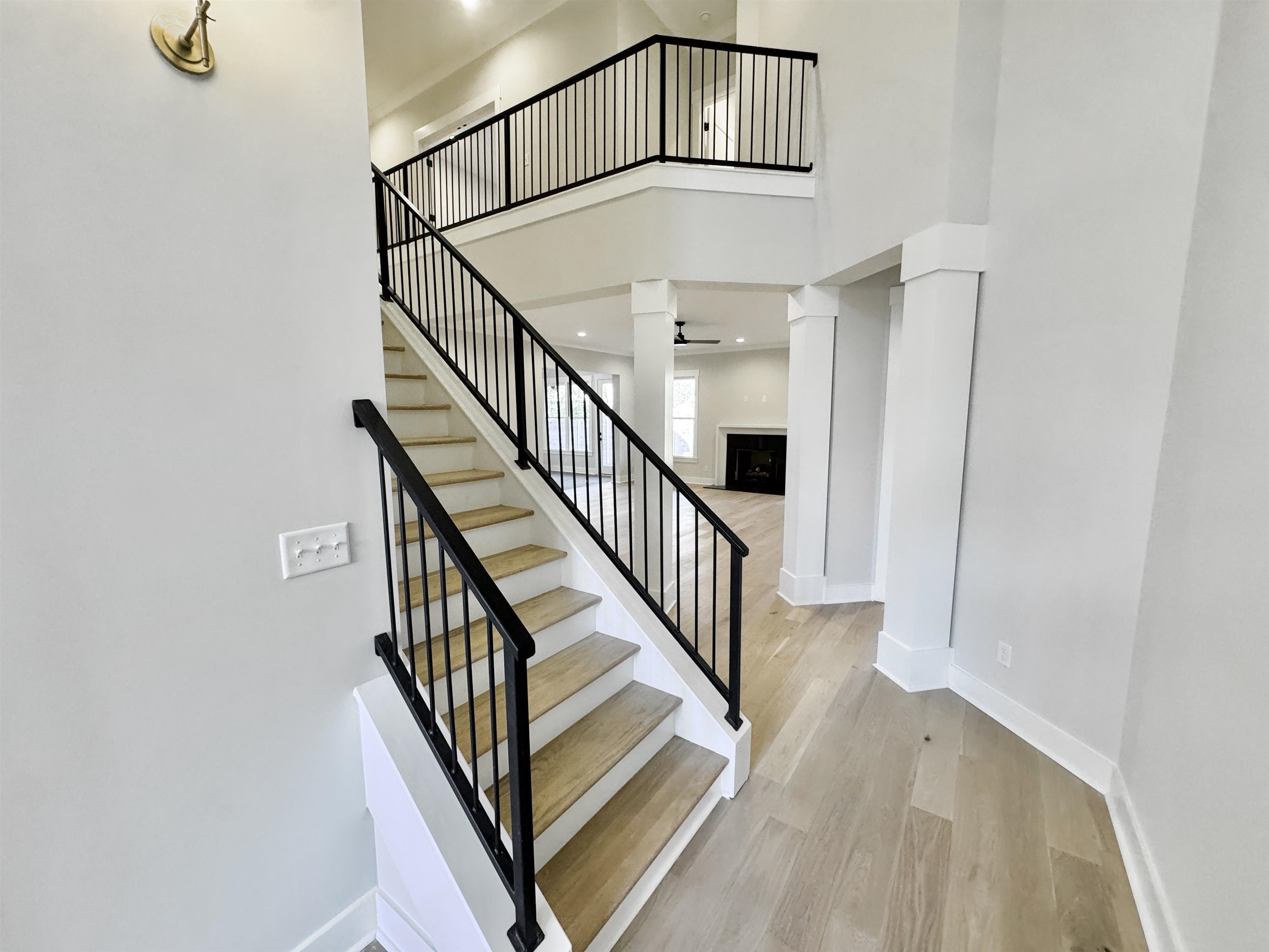 354 Avon Road Memphis, TN 38117 - Photo 5 of 40 Staircase with a high ceiling, wood finished floors, a fireplace, and recessed lighting