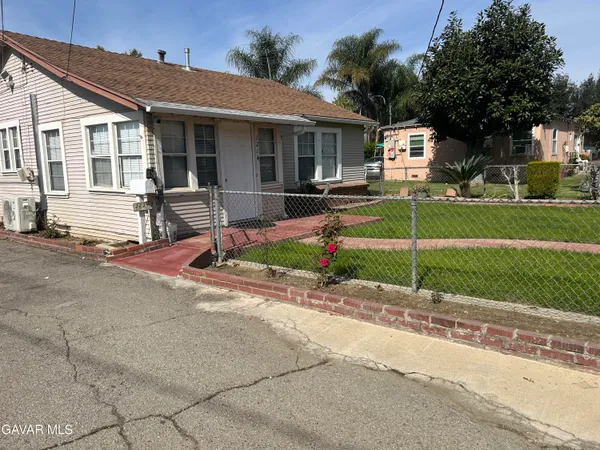 a front view of a house with a garden and plants