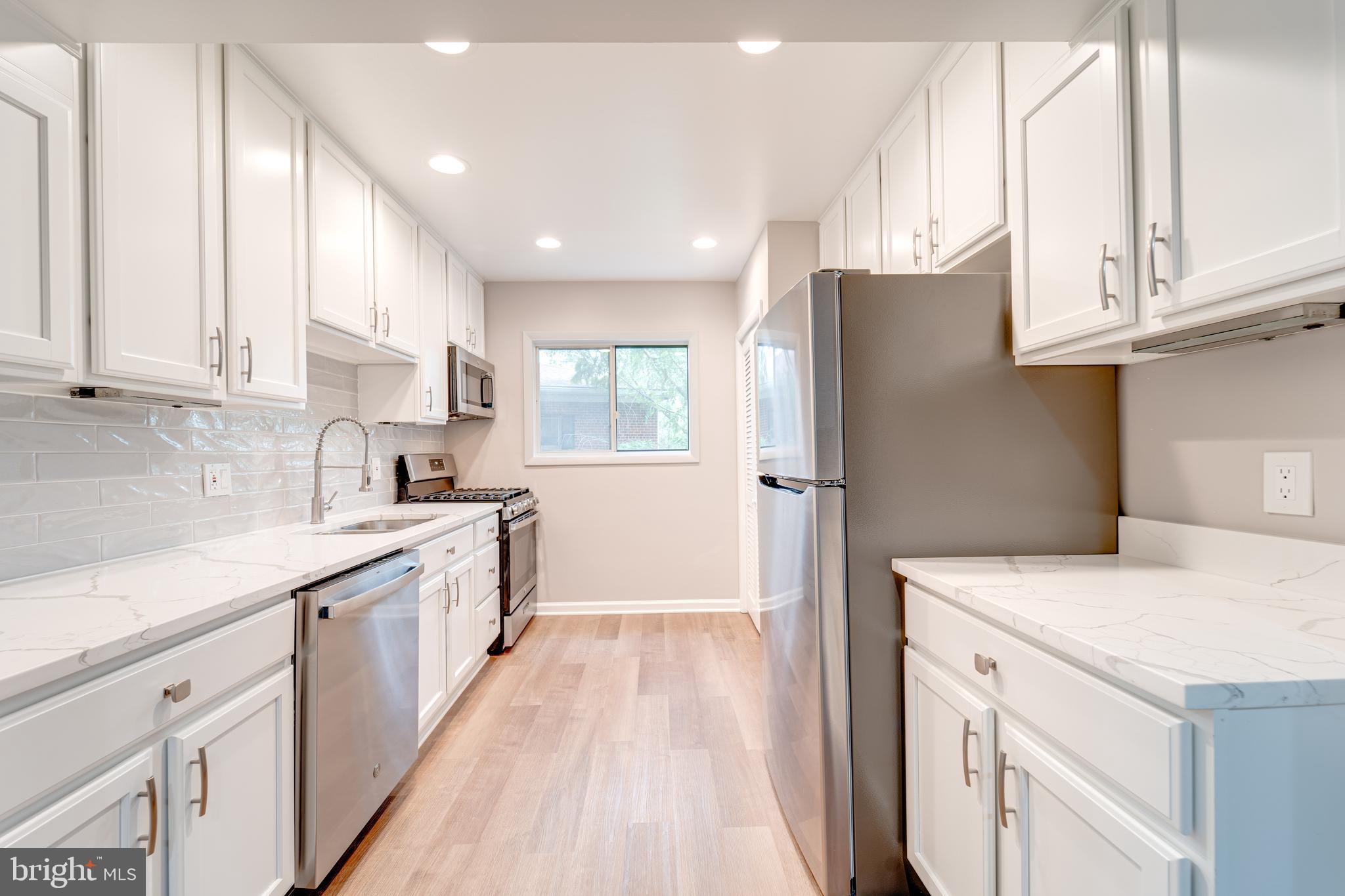 51 Skyhill Road, Unit 202 Alexandria, VA 22314 - Photo 7 of 23 a kitchen with white cabinets and refrigerator