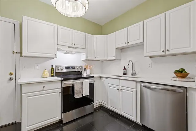 a kitchen with white cabinets and white appliances