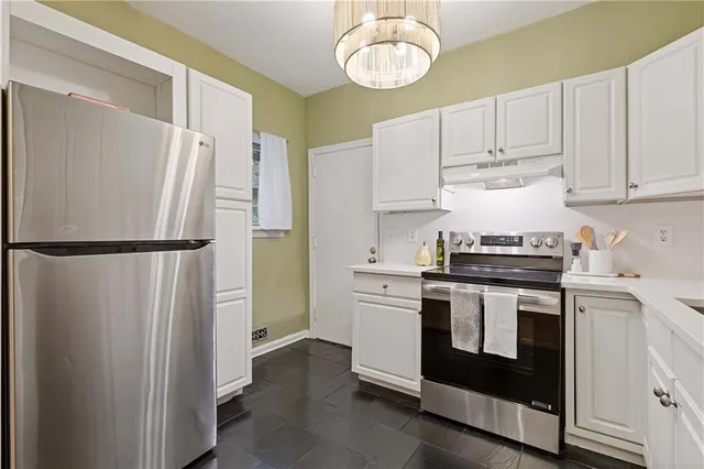 a kitchen with stainless steel appliances a stove a refrigerator and cabinets