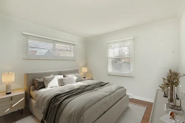 a bedroom with a bed and a potted plant next to a window