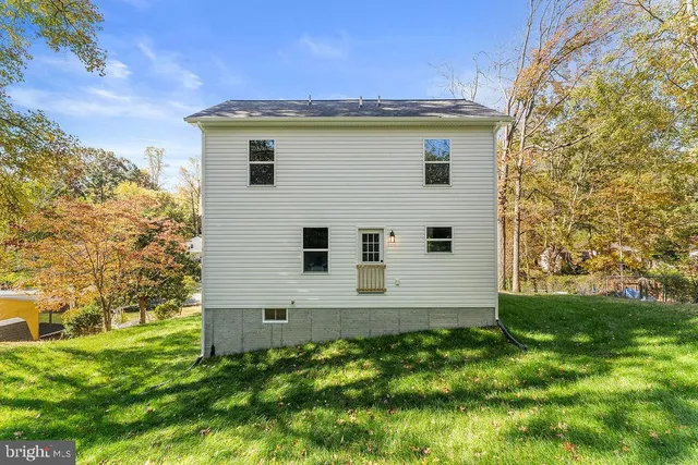 a front view of a house with a yard and trees