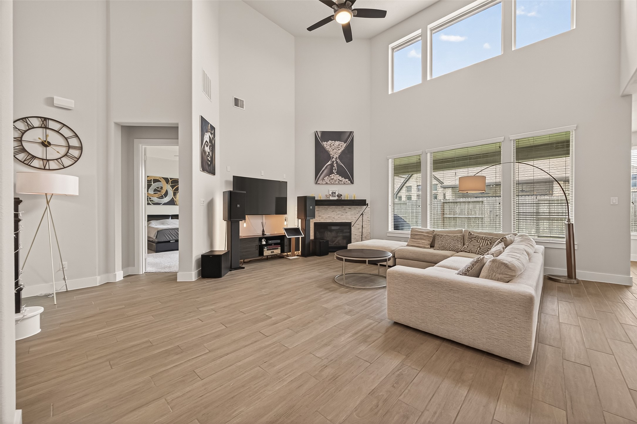1815 Brea Rdg Trail Katy, TX 77494 - Photo 7 of 43 This spacious living room features high ceilings, large windows for natural light, a modern fireplace, and sleek wood flooring. The open layout includes a comfortable seating area and stylish decor, creating an inviting atmosphere.