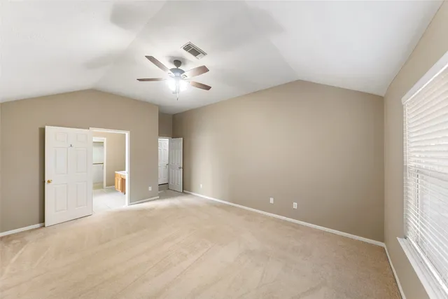 an empty room with windows and fan