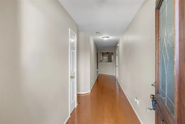 a view of a hallway with wooden floor