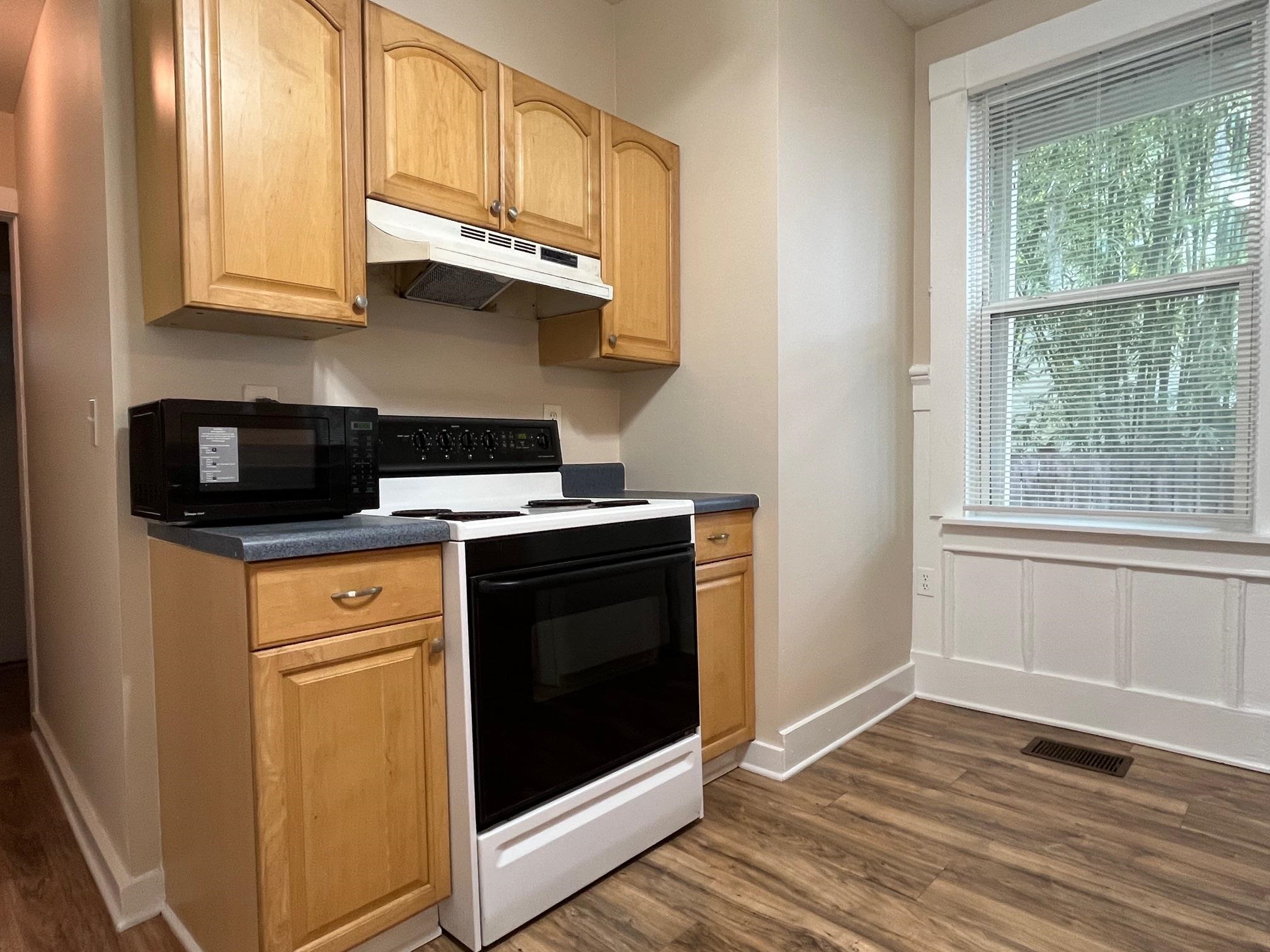 25 Desoto Place, Unit 2 St. Augustine, FL 32084 - Photo 3 of 14 a kitchen with stainless steel appliances granite countertop a stove a microwave and a white cabinets