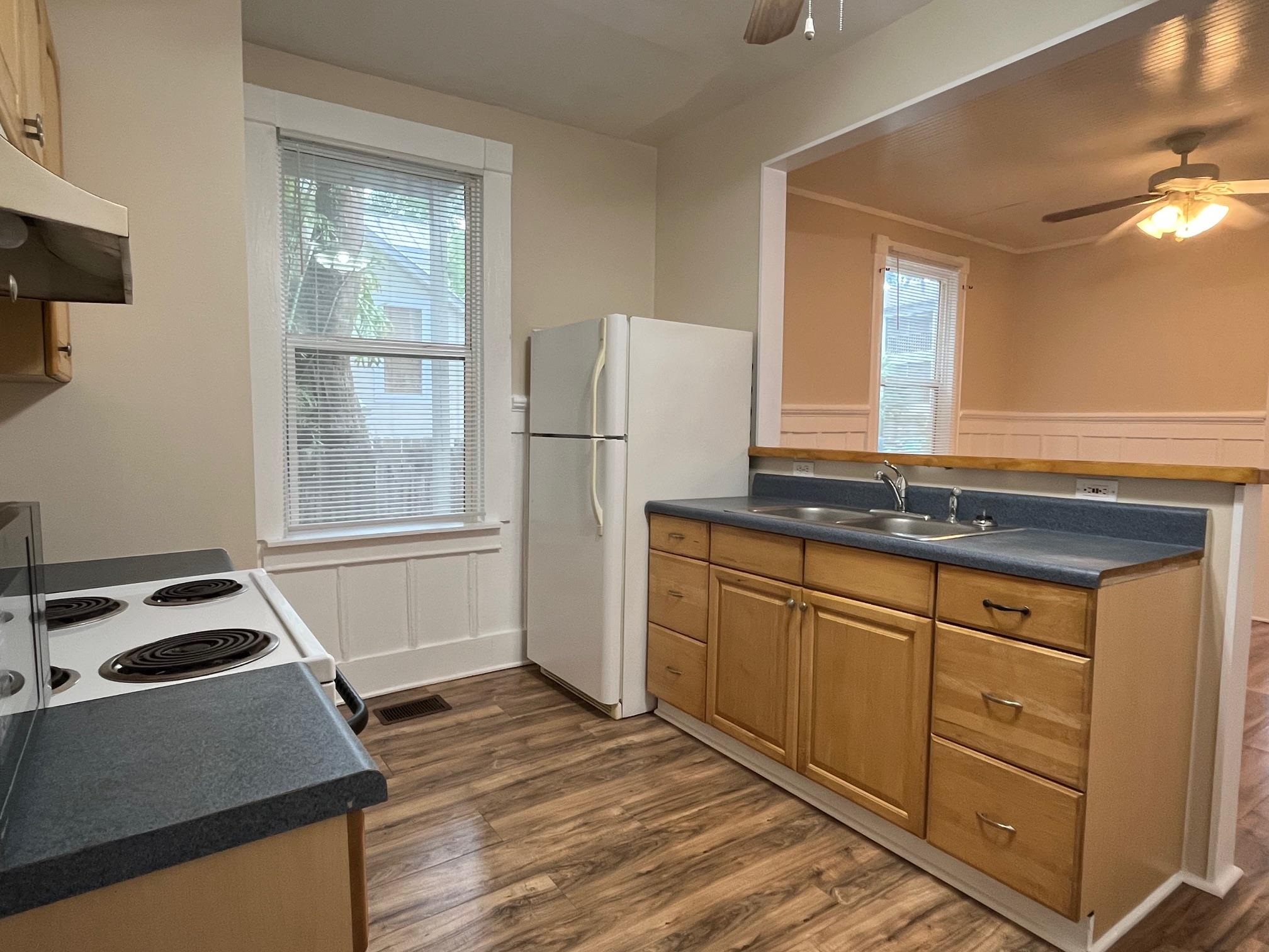 25 Desoto Place, Unit 2 St. Augustine, FL 32084 - Photo 4 of 14 a kitchen with granite countertop a refrigerator and a sink