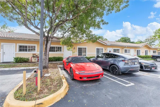 a front view of a house with cars parked