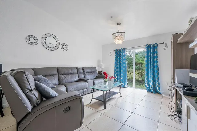 a living room with furniture a flat screen tv and a large window