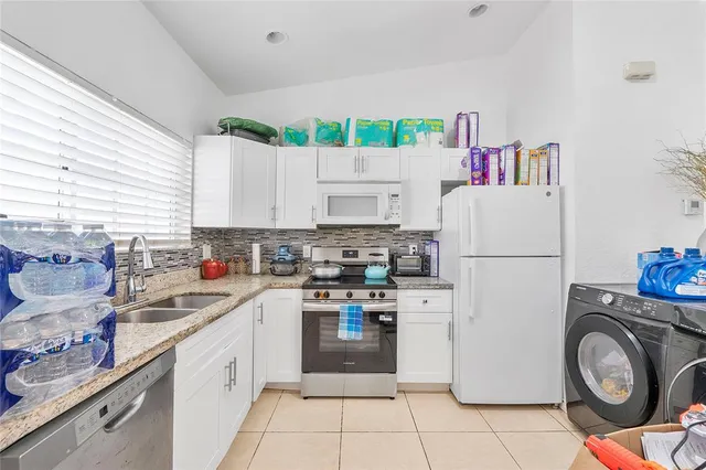 a kitchen with a refrigerator a stove and a sink