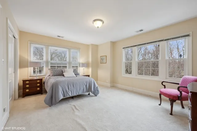 a spacious bedroom with a bed and a chair