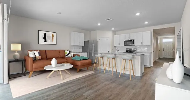 a living room with furniture and kitchen view
