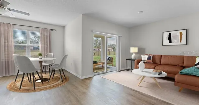 a living room with furniture a wooden floor and a large window