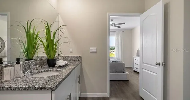 a en suite bathroom with granite countertop a sink and a mirror