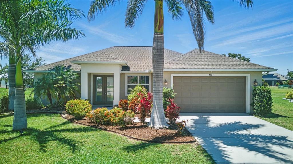 7505 Carissa Punta Gorda, FL 33955 - Photo 1 of 57 a front view of a house with a yard and potted plants