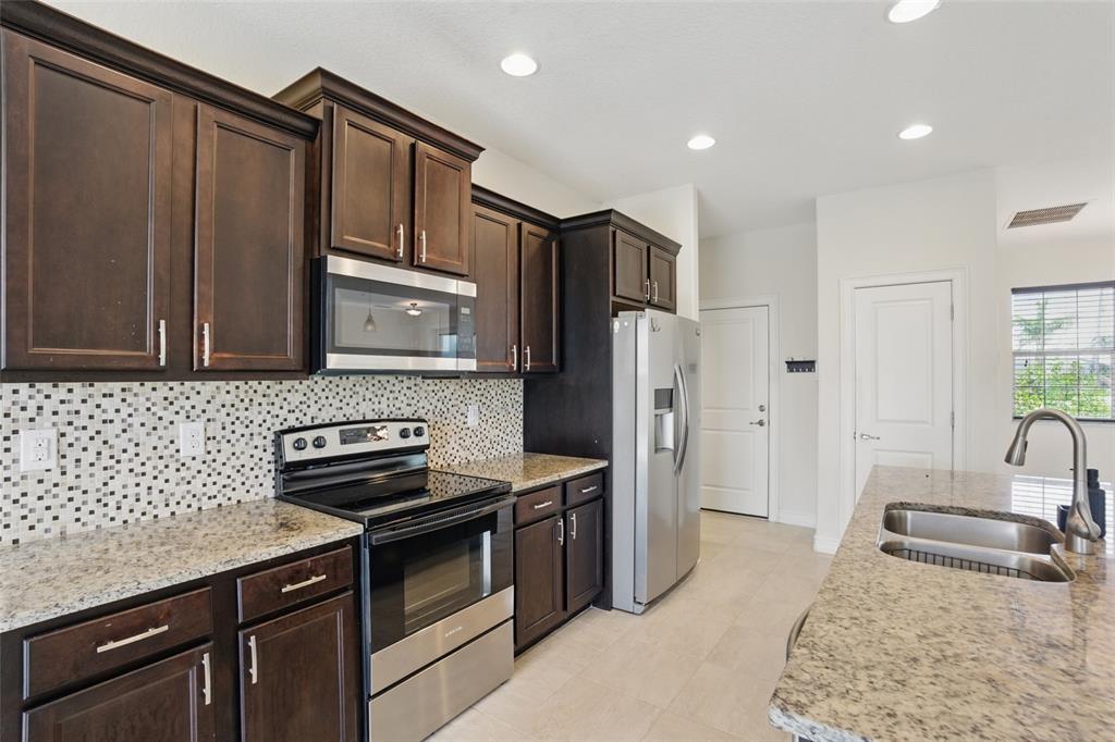 7505 Carissa Punta Gorda, FL 33955 - Photo 22 of 57 a kitchen with stainless steel appliances granite countertop a sink stove and refrigerator