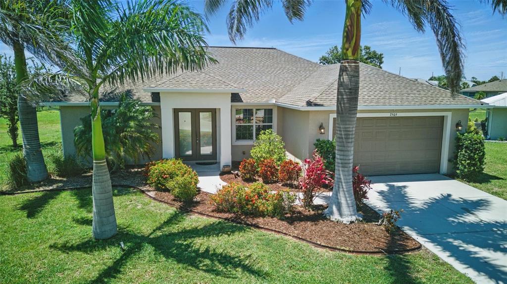 7505 Carissa Punta Gorda, FL 33955 - Photo 3 of 57 a front view of a house with a yard and potted plants