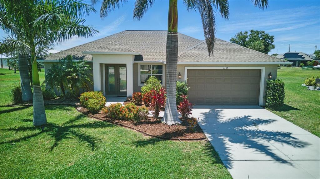 7505 Carissa Punta Gorda, FL 33955 - Photo 4 of 57 a front view of a house with a yard and garage