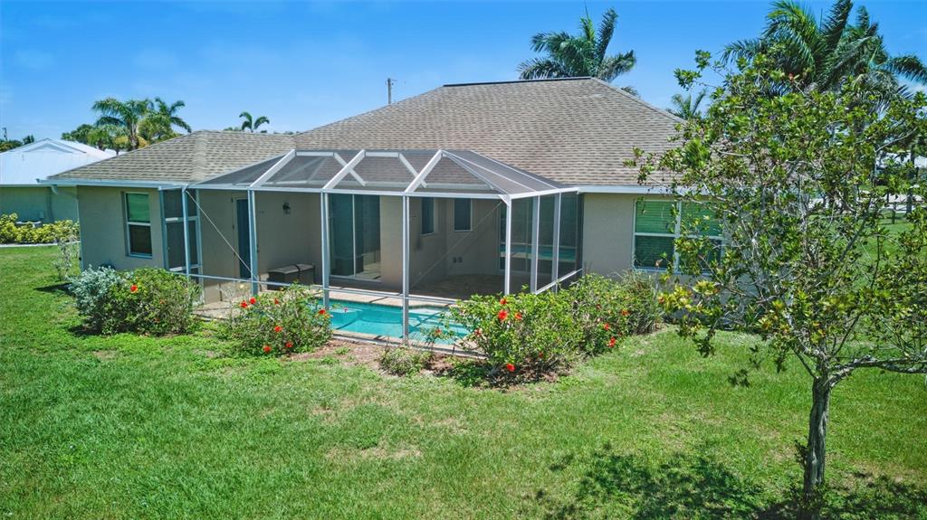 7505 Carissa Punta Gorda, FL 33955 - Photo 52 of 57 a view of a white house with a yard and potted plants