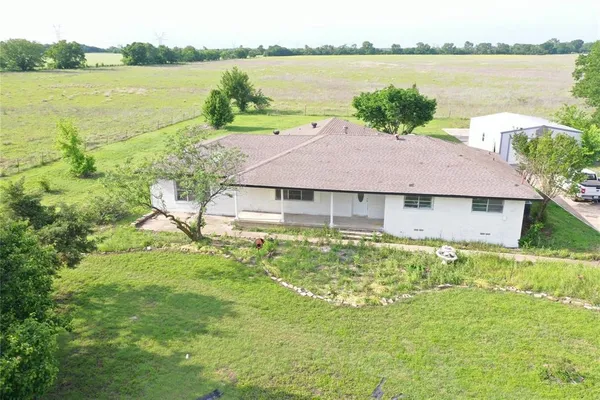 a aerial view of a house with a yard and a lake view