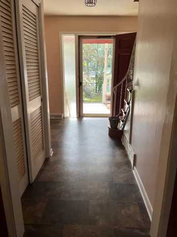 a view of a hallway with wooden floor and stairs