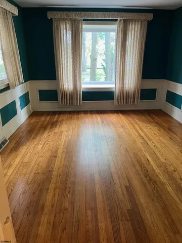 a view of a livingroom with wooden floor and furniture