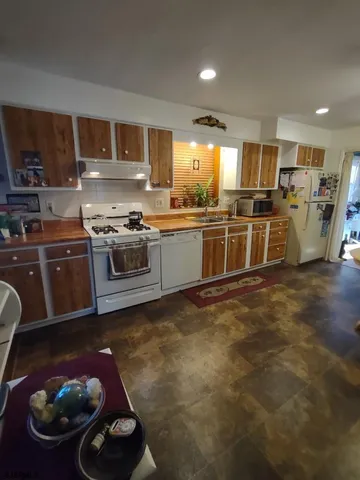 a large kitchen with stainless steel appliances granite countertop a stove and a sink
