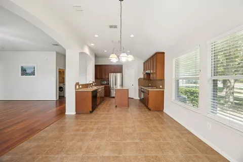 a view of a kitchen with refrigerator and windows