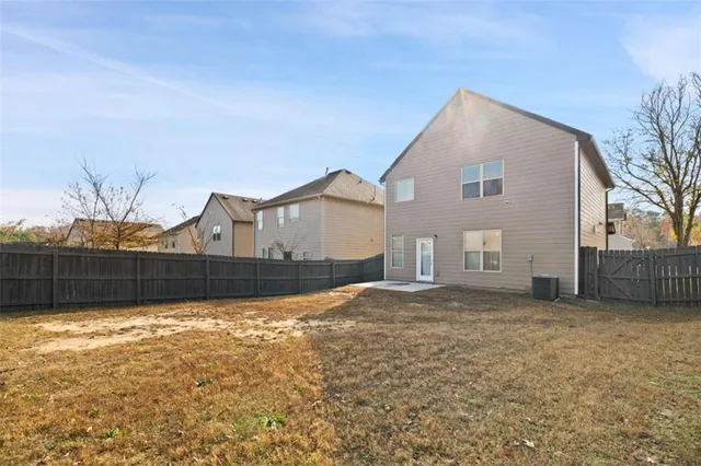 a view of a house with a yard and large tree