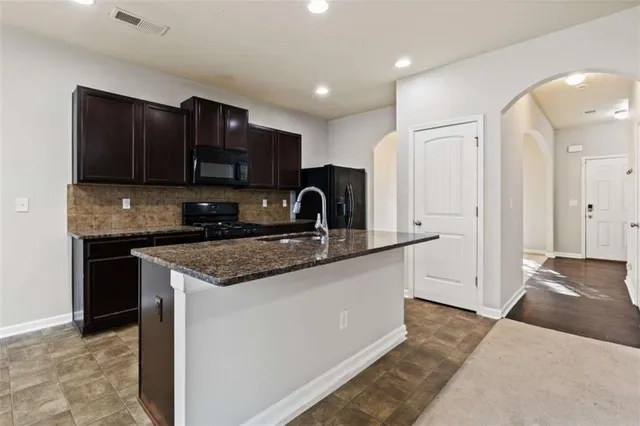 a kitchen with stainless steel appliances granite countertop a sink stove and cabinets