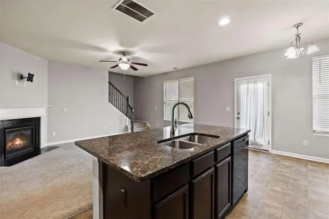 a kitchen with a sink a chandelier and fireplace