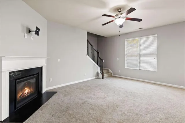 an empty room with windows and fireplace