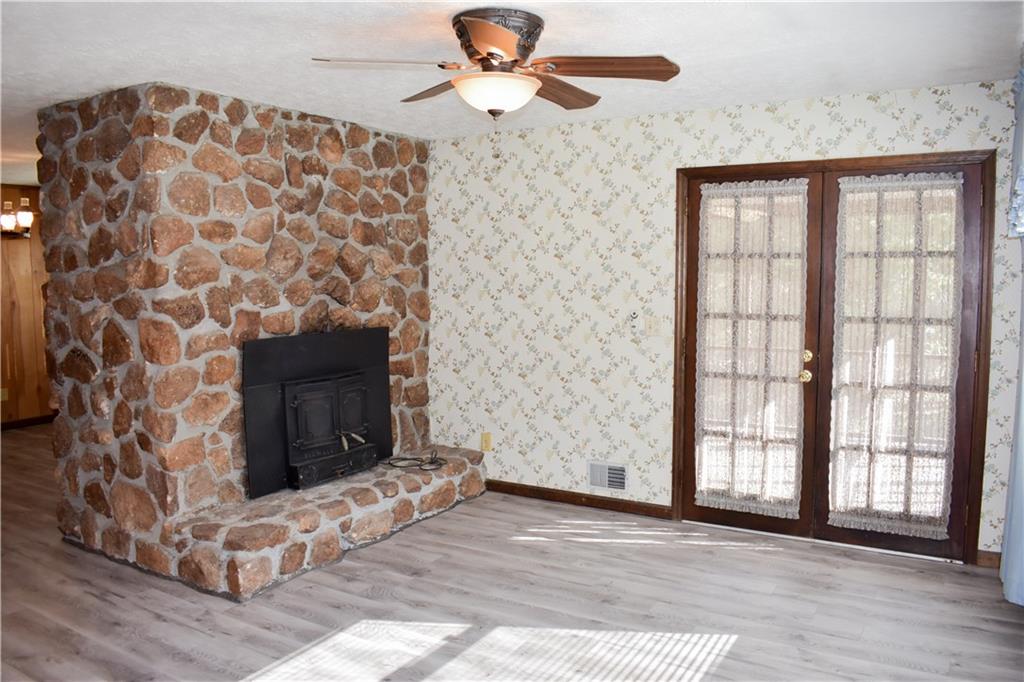 6882 Cowan Mill Road Winston, GA 30187 - Photo 8 of 50 a view of empty room with fireplace and wooden floor