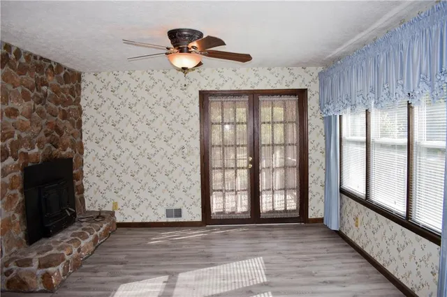 a view of a livingroom with wooden floor and a fireplace