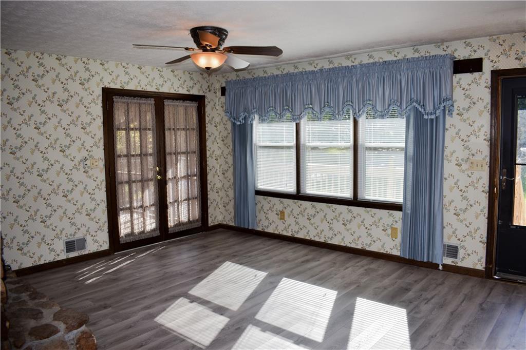 6882 Cowan Mill Road Winston, GA 30187 - Photo 10 of 50 a view of an empty room with a window and wooden floor