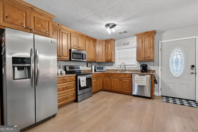 a kitchen with granite countertop a refrigerator stove and microwave
