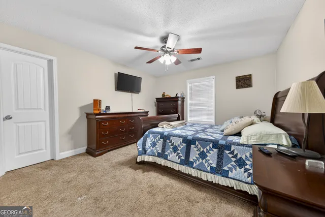 a bed room with a bed and a ceiling fan