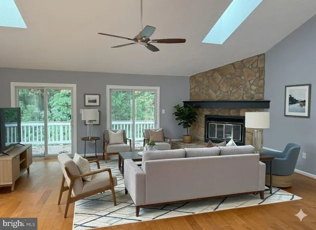 a living room with furniture wooden floor and a large window