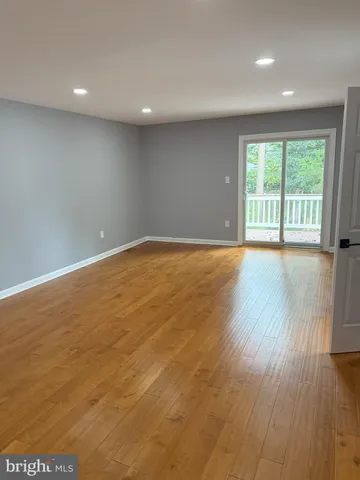 a large bedroom with a bed and wooden floor